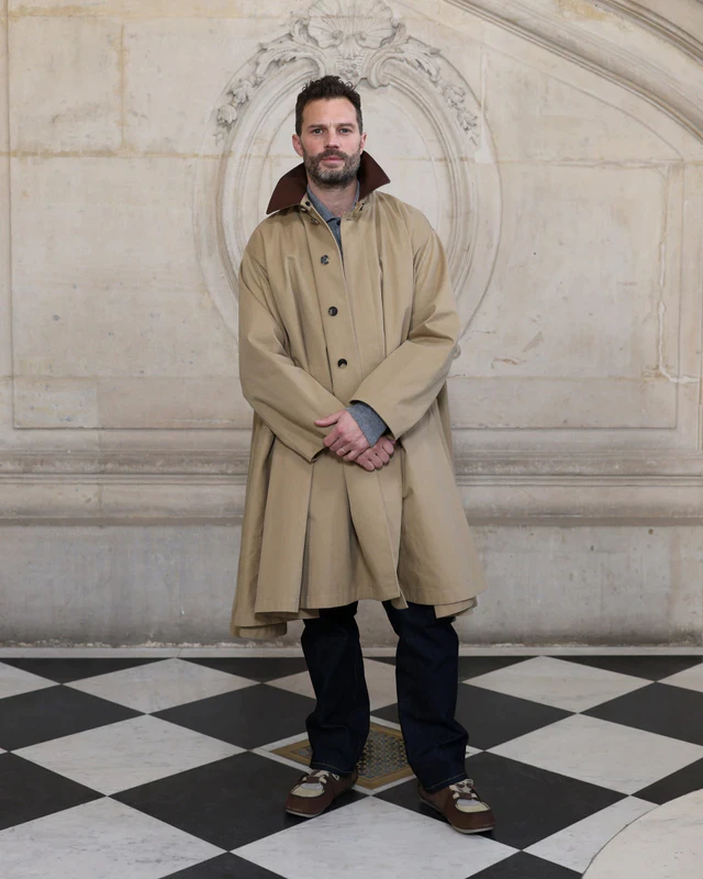 ジェイミー・ドーナンはベージュコットンのトレンチコートにグレーのカシミアカーディガン、ブラックのデニムジーンズを合わせ、ディオールのアクセサリーも着用しました。