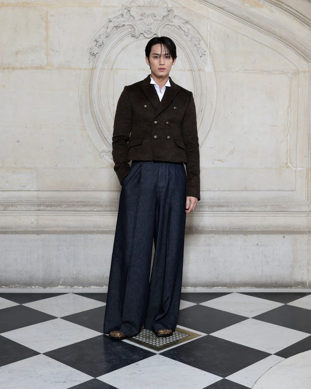 ディオール 2026-2027年ウィンター コレクション ミンギュは、ブラウンウールの「バー」ジャケットに、ホワイトコットンのウィングチップカラーシャツ、ネイビーのウールパンツを合わせた装いで登場しました。ディオールのアクセサリーも着用しました。